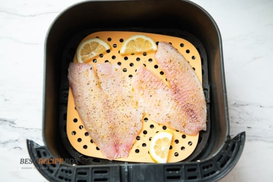 Uncooked white fish in air fryer basket