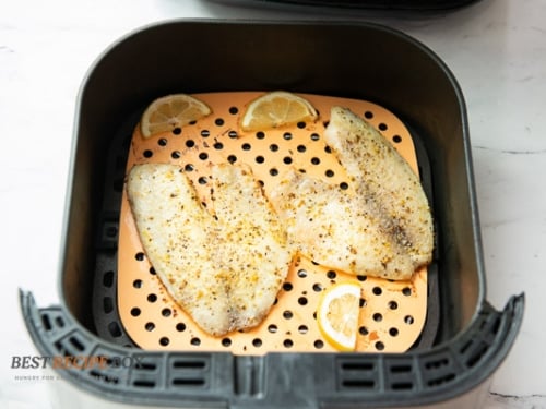 Cooked white fish in air fryer basket