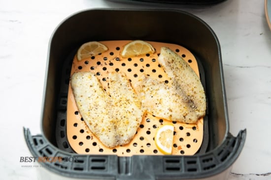Cooked white fish in air fryer basket