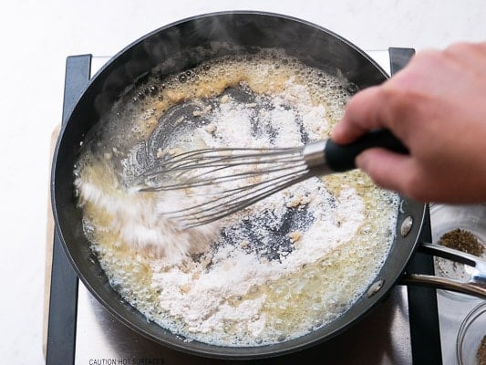 Whisking flour into the garlic and butter