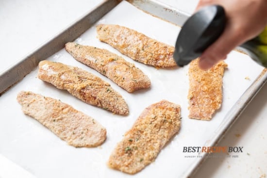 Spraying fish fillets with oil