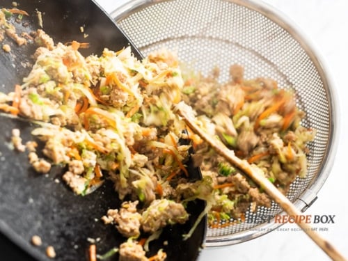 Placing cooked chicken in a colander