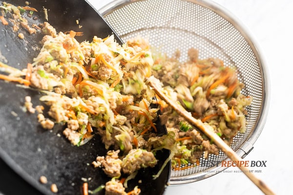 Placing cooked chicken in a colander