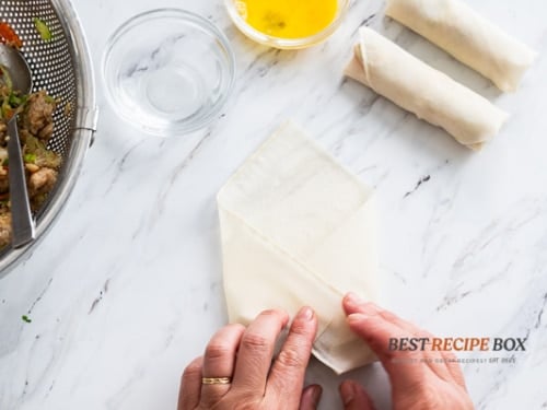 Tucking the sides of the wrapper around the filling
