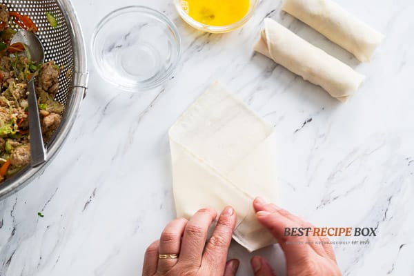 Tucking the sides of the wrapper around the filling