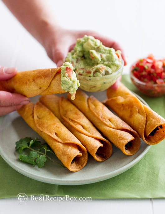 Easy Crispy Chicken Taquitos recipe or Rolled Chicken Tacos on a plate with guacamole
