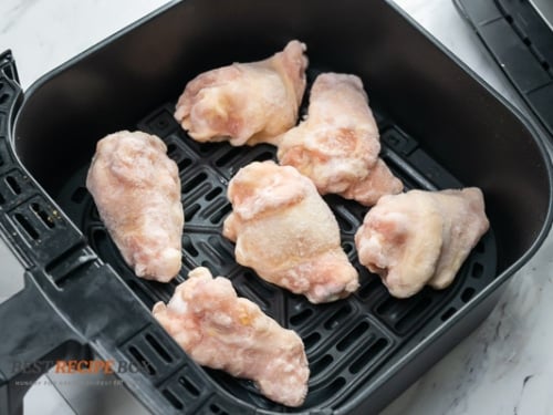 Frozen chicken wings in air fryer basket