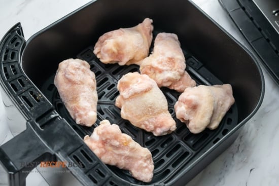 Frozen chicken wings in air fryer basket