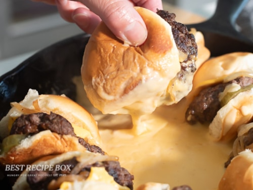 holding cheesy slider in sauce