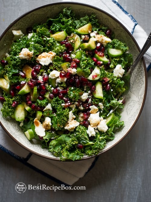 Healthy Kale Salad Recipe with Pomegranates, Feta Cheese and Cucumbers in a bowl 