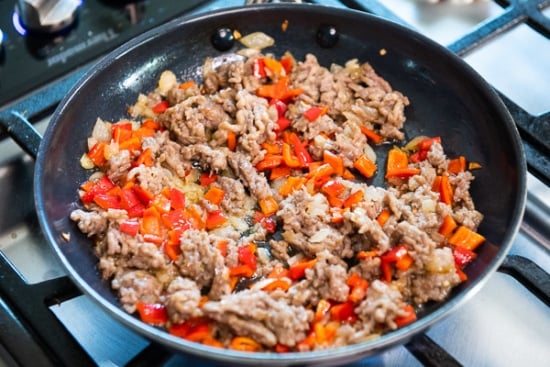Sausage, onion and bell peppers cooked in a skillet