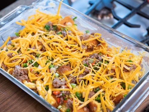 Cornbread, sausage, and cheese layered in the baking dish