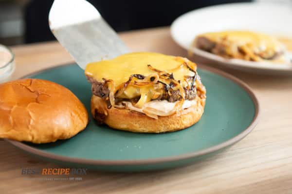 finishing the burger with sauce and buns