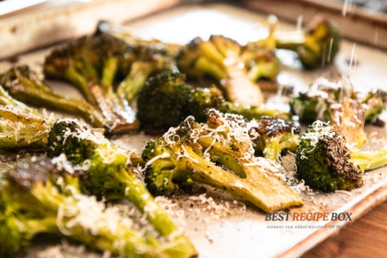 Roasted broccoli topped with parmesan on baking sheet pan