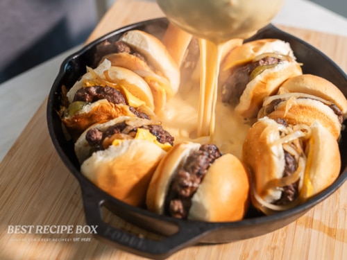 pouring hot cheese sauce into slider pan