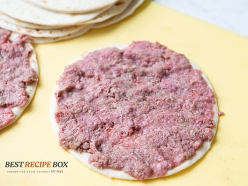 Beef flattened on top of a tortilla