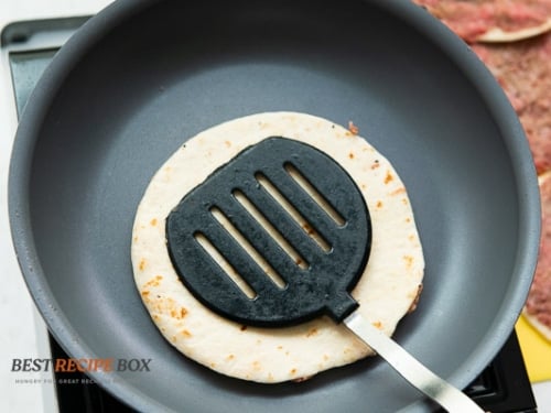 Tortilla, meat side down on pan
