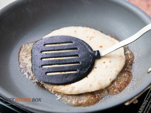 Pressing tortilla with a spatula