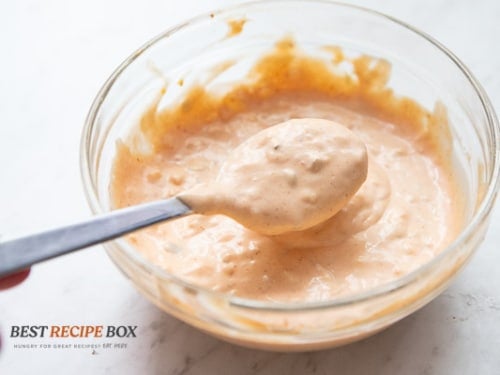 Burger sauce in a spoon over bowl of sauce