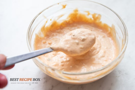 Burger sauce in a spoon over bowl of sauce