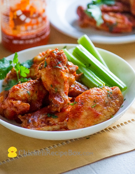 Healthy Sriracha buffalo wings recipe in a bowl with celery