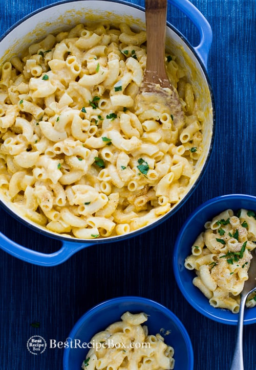 Amazing and easy stovetop creamy mac and cheese recipe in a cooking pot with wooden spoon