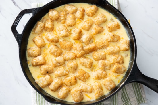 Tater tots placed over egg mixture in skillet